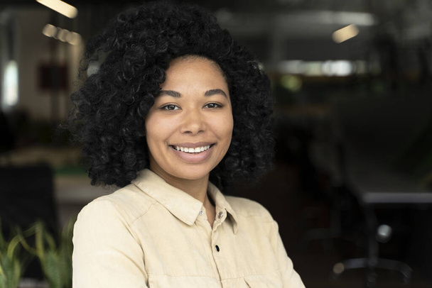 Retrato confiante de uma jovem afro-americana de sucesso, gerente de vendas intencional, CEO, diretor executivo, trabalhador de escritório sorrindo olhando com confiança para a câmera, de pé no escritório corporativo - Foto, Imagem