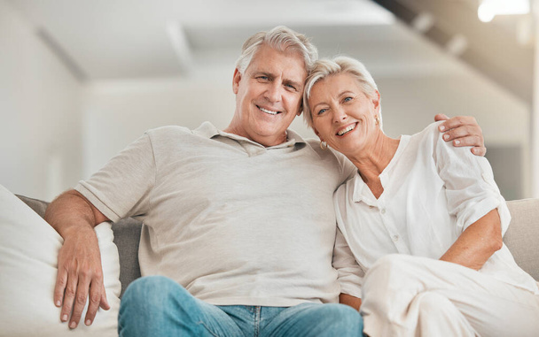 Πρεσβύτερος, πορτρέτο ή ευτυχισμένο ζευγάρι αγκαλιά στο σπίτι με αγάπη στον καναπέ για να δεθούν σε μια δέσμευση γάμου μαζί. Χαμόγελο, πρόσωπο ή ώριμα άτομα στη συνταξιοδότηση με φροντίδα ή υποστήριξη στο σαλόνι για να χαλαρώσετε. - Φωτογραφία, εικόνα