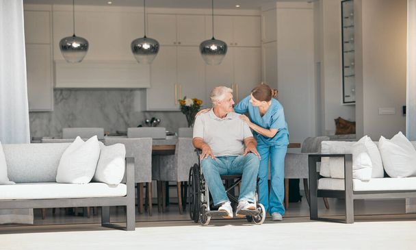 Woman, doctor and elderly care with wheelchair for support, trust or nursing in retirement or old age home. Female nurse or caregiver talking to senior man or person with a disability in living room. - Photo, Image