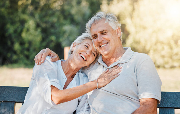 シニアハッピーカップル, 笑ったり公園のベンチ 愛のために, サポートまたは債権引退信頼. 笑顔,リラックス,または高齢男性は,冗談,面白いニュースや関係で裏庭で女性を抱擁. - 写真・画像