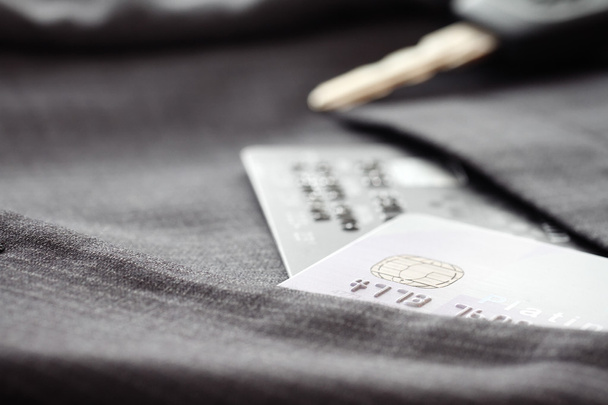 Carte di credito a fuoco molto superficiale con sfondo abito grigio
 - Foto, immagini