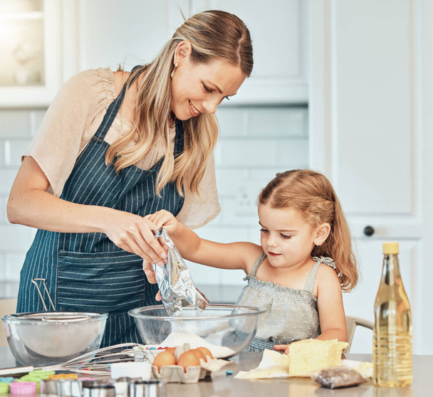 Μαμά, κορίτσι παιδί και διδασκαλία για το μαγείρεμα, την ανάπτυξη και τις δεξιότητες με το δέσιμο, την αγάπη και τη φροντίδα στο σπίτι της οικογένειας. Ψήσιμο, μητέρα και κόρη με μπολ, αλεύρι και αυγά στο τραπέζι, κουζίνα και βοήθεια για φαγητό. - Φωτογραφία, εικόνα