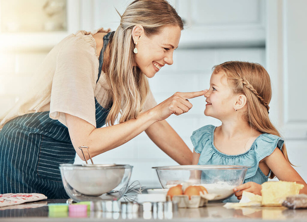 Anne ve kızı, mutfakta oynamak için yemek pişiriyor ve gülümsüyor ve birbirlerine bağlanıyorlar. Mutlu aile, taze malzemeler ve öğrenme, pasta ve tatlı ya da kahvaltıda pasta, atıştırmalık ve evde yemek.. - Fotoğraf, Görsel