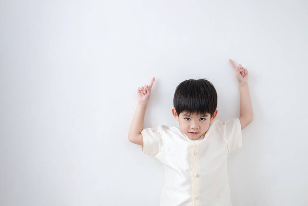 Asian boy Wearing traditional Thai clothing, standing with index finger upwards. on a white background - Photo, Image