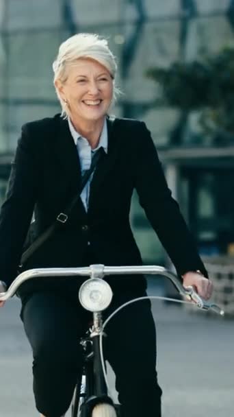 Ältere glückliche Frau, Geschäfts- und Fahrradreisen zu Bürogebäuden, Geschäftsterminen oder auf morgendlichen Pendel-, Ausflugs- oder Reisewegen. CO2-neutraler Transport, umweltfreundliches Radfahren oder Stadtmensch auf dem Fahrrad. - Filmmaterial, Video