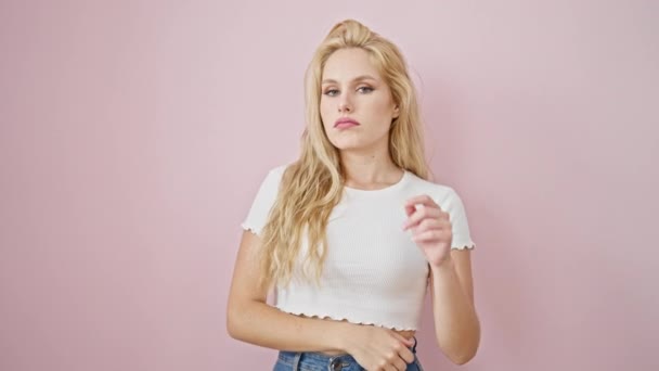 Young blonde woman smiling confident standing over isolated pink background - Metraje, vídeo