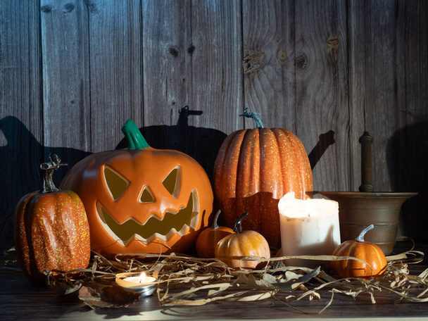 Halloween pumpkin head lantern with candles an pumpkin on wooden background - Photo, Image