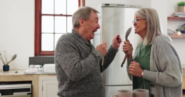 Karaoke, senior couple and cooking singing in kitchen together for playful bonding. Smile, fun and elderly man and woman with love, dance and music while preparation for dinner, lunch or breakfast. - Footage, Video