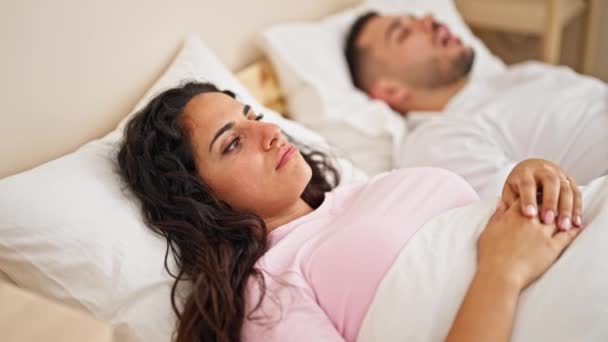 mężczyzna i kobieta para leżące na łóżku cierpiące bezsenność dla chrapać w sypialni - Materiał filmowy, wideo