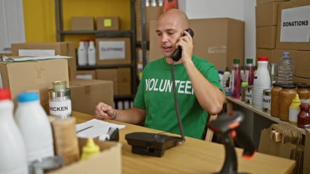Nuori latino mies vapaaehtoinen puhuu puhelimessa stressaantunut hyväntekeväisyyskeskuksessa - Materiaali, video