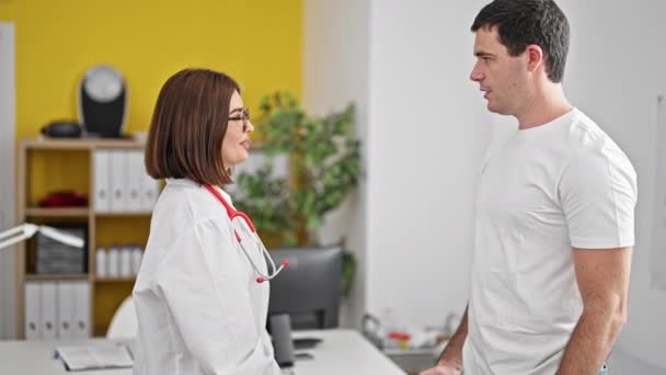 Лікар і пацієнт потискають руки посміхаючись у клініці - Кадри, відео