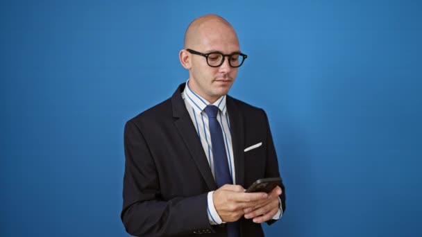 Giovane ispanico uomo d'affari lavoratore utilizzando smartphone sorridente su isolato sfondo blu - Filmati, video