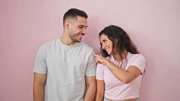 Man and woman couple standing together dancing over isolated pink background - Footage, Video