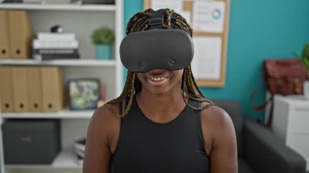 Afrikai amerikai nő üzleti dolgozó visel virtuális valóság szemüveg mosolyog az irodában - Felvétel, videó
