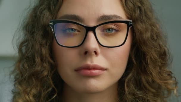 Mosolygó lány divatos szemüveg pózol egyedül. Boldog Y-generációs lány diák profi közelről portré 4K lassú. Gyönyörű magabiztos fiatal ukrán nő kék szemekkel nézi RED kamera - Felvétel, videó
