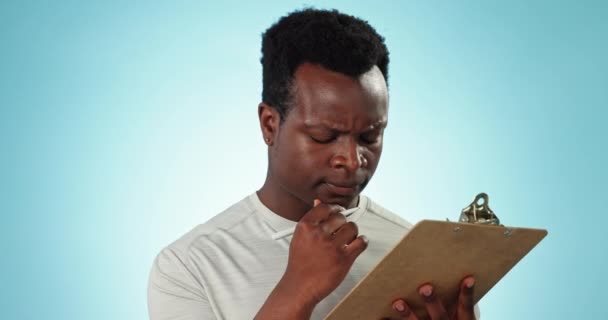 Düşünme, çözüm ve siyah bir adam strateji, program ya da gündem için notlar okuyor. Mavi arkaplan, fikir ve evrak, belge veya sözleşme anlaşması için panosu olan Afrikalı bir kişi. - Video, Çekim