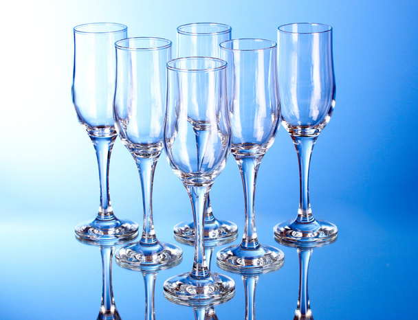 Few empty wine glasses on blue background - Foto, Imagen