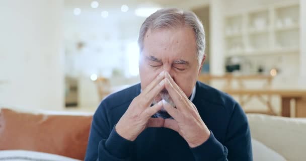 Stress, headache and senior man in living room with sick, burnout or facial pain at modern home. Migraine, frustrated and elderly male person in retirement thinking in the lounge of his house - Footage, Video