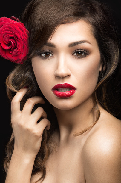 Beautiful girl in the Spanish way of Carmen with red lips and a rose in her hair.  Beauty face. - 写真・画像