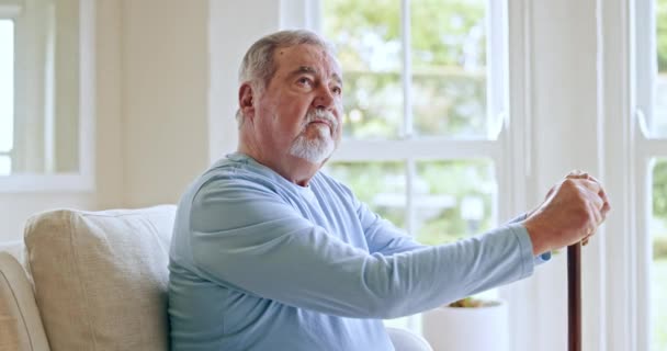 Idős ember, sétapálca és gondolkodás otthon vagy a nappaliban nosztalgiával, memóriával vagy döntéssel nyugdíjba vonuláskor. Idősek, demenciában szenvedők és Alzheimer-kórban szenvedők emlékeznek a múltra vagy a történelemre a házban. - Felvétel, videó