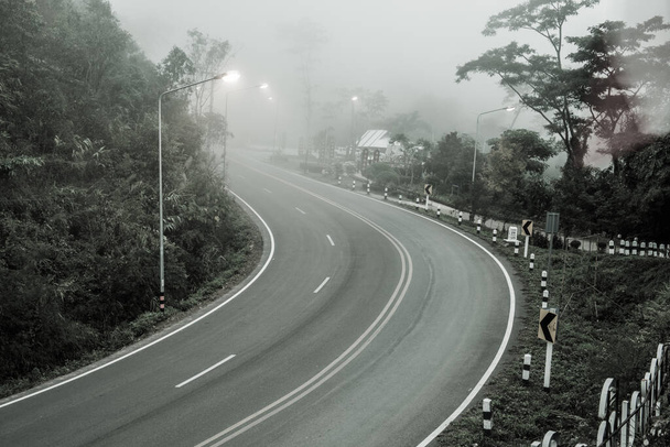 Bochtige weg met mist, Thailand. - Foto, afbeelding