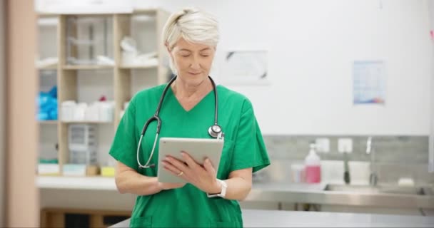 Tablet, woman and senior nurse research, telehealth and online communication in clinic. Technology, serious and medical professional on internet, scroll on wellness app or typing email for healthcare. - Footage, Video