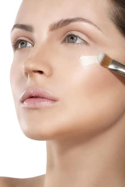 Beautiful model applying foundation with a brush - Foto, Imagen