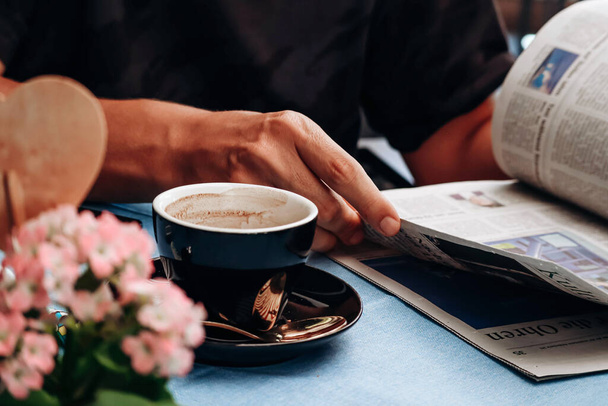 Mann liest Zeitung beim Kaffeetrinken in Restaurant - Foto, Bild