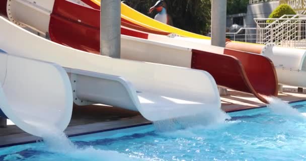 Colorful water slides in water park with water. Summer holidays and skiing - Footage, Video