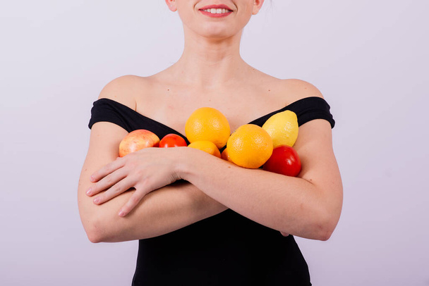 Hymyilevä viileä tyttö aurinkolasit musta uimapuku poseeraa hedelmiä ja nauraa. - Valokuva, kuva