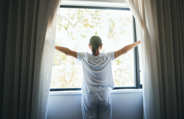 Geöffnet, Vorhänge und Rücken der Frau am Fenster für Aufwachen, Sonnenaufgang und guten Morgen im Schlafzimmer zu Hause. Wach, Vorhänge und Sonnenlicht für Inspiration, entspannende Aussicht oder einen strahlenden neuen Tag. - Foto, Bild