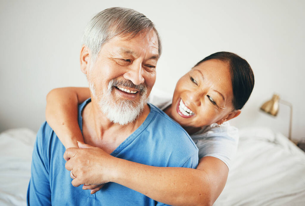 Senior, smích nebo šťastný pár objetí v domě ložnice společně relaxovat na dovolené s dluhopisy nebo podporu. Obejmout, vtipné nebo romantické asijské muž s zralou ženou s láskou, úsměvem nebo péčí v manželství. - Fotografie, Obrázek