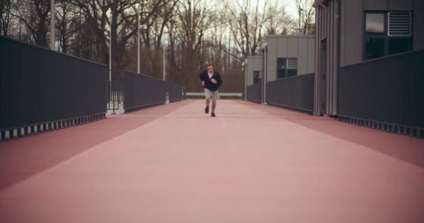 Determinante giovane sportiva che corre sul campo sportivo in giardino - Filmati, video