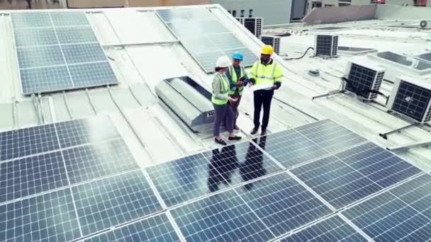 Engineering, team or aerial view with solar panel outdoor for construction, design and inspection. Photovoltaic, people or planning or blueprint with discussion, conversation or collaboration on roof. - Footage, Video