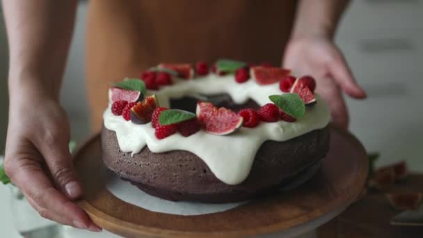 Шеф-кухар випічки завершує роботу над тортами на день народження. Жінка прикрашає смачний торт ягодами, вершками та зеленим листом м'яти. Смачний домашній десерт. Процес випічки.  - Кадри, відео