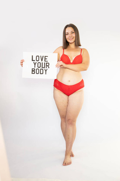 Portrait of self loving woman plus size in red underwear on white background, body love - Photo, Image