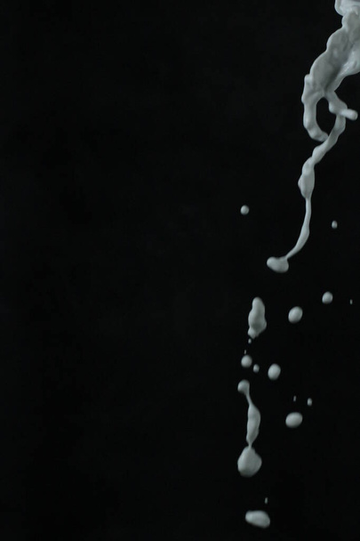 Fehér festék Splash-fekete háttér. - Fotó, kép