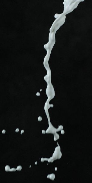 salpicadura de pintura blanca sobre fondo negro - Foto, imagen