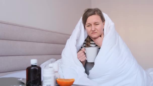 Doente chateado jovem mulher sentada na cama coberta com cobertor, pego frio, menina doente tem sintomas de gripe, tosse em casa, conceito de gripe. - Filmagem, Vídeo