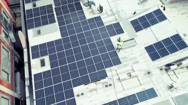 Top view, solar panels or group with teamwork, sustainability or buildings with cooperation. People, staff or workers with engineering, electricity or renewable energy with partnership or maintenance. - Footage, Video