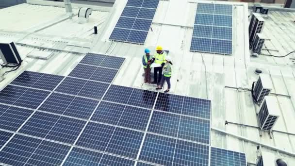 Engineering, team or aerial view with photovoltaic outdoor for construction, design and inspection. Solar panel, people or planning or blueprint with discussion, conversation or collaboration on roof. - Footage, Video