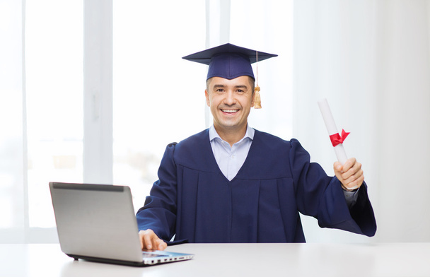 smiling adult student in mortarboard with diploma - Photo, Image