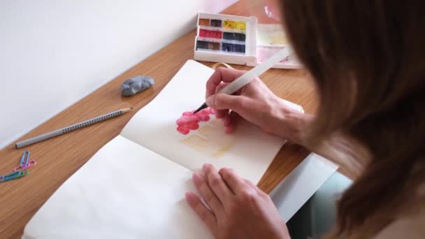 closeup of unrecognizable woman drawing with watercolor paint, making sketch of a cake - Imágenes, Vídeo