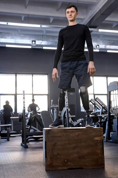 ambitious motivated man in sportswear standing on box, full length photo. free time, spare time, health and body care. wellness - Фото, изображение