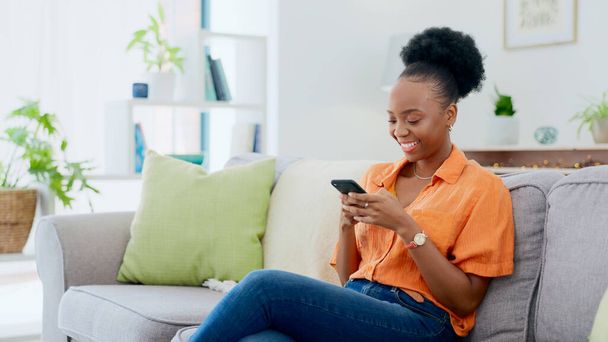 Relaks, rozmowa telefoniczna lub czarna kobieta na kanapie w komunikacji w salonie. Uśmiech, przewijanie lub szczęśliwy Afrykanin smsowanie lub czytanie plotek online na temat dyskusji aplikacji mobilnej na kanapie w domu. - Zdjęcie, obraz
