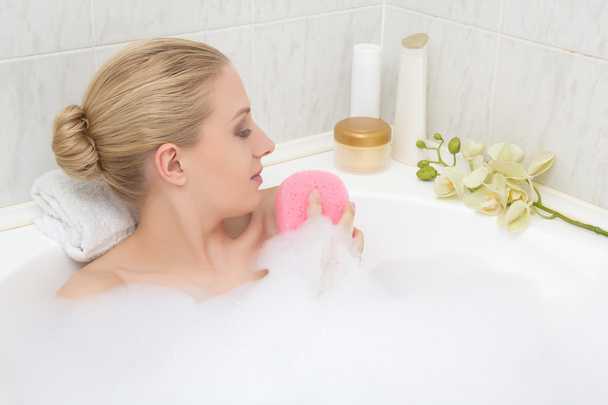 Frau im Bad entspannen und sich von Schwamm waschen - Foto, Bild