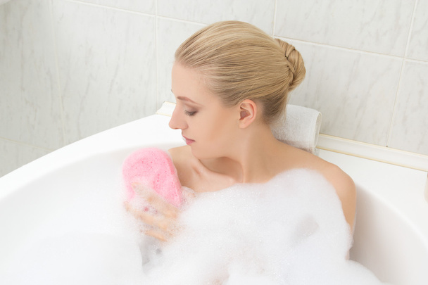 woman relaxing in bath and washing herself - Photo, Image
