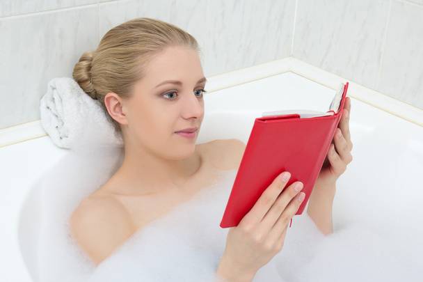 woman relaxing in bath and reading book - Фото, изображение