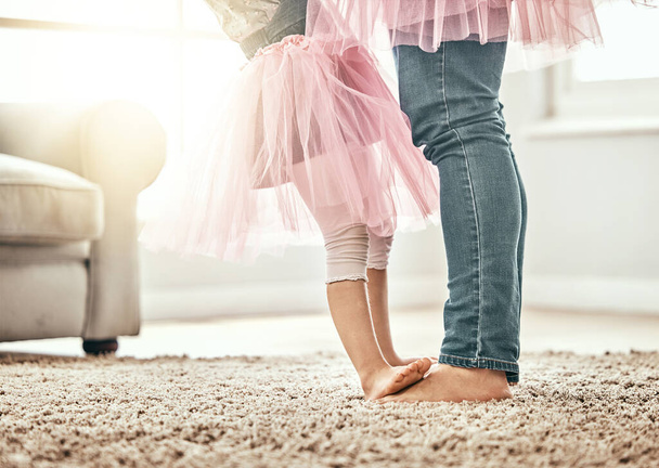 Μπαλέτο, πόδια και πατέρας με κορίτσι σε ένα σαλόνι με αγάπη, μάθηση ή χορό στο σπίτι τους μαζί. Οικογενειακός χρόνος, δεσμός και πόδια παιδιού με γονέα σε σπίτι για υποστήριξη, φροντίδα και ασφάλεια. - Φωτογραφία, εικόνα