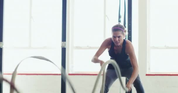 Žena atlet, bojová lana a energie s rychlým cvičením v tělocvičně, fitness a odbojový trénink. Sportovní, aktivní a ženské osoby u moci s kardio, cvičení a pot pro silné tělesné svaly. - Záběry, video
